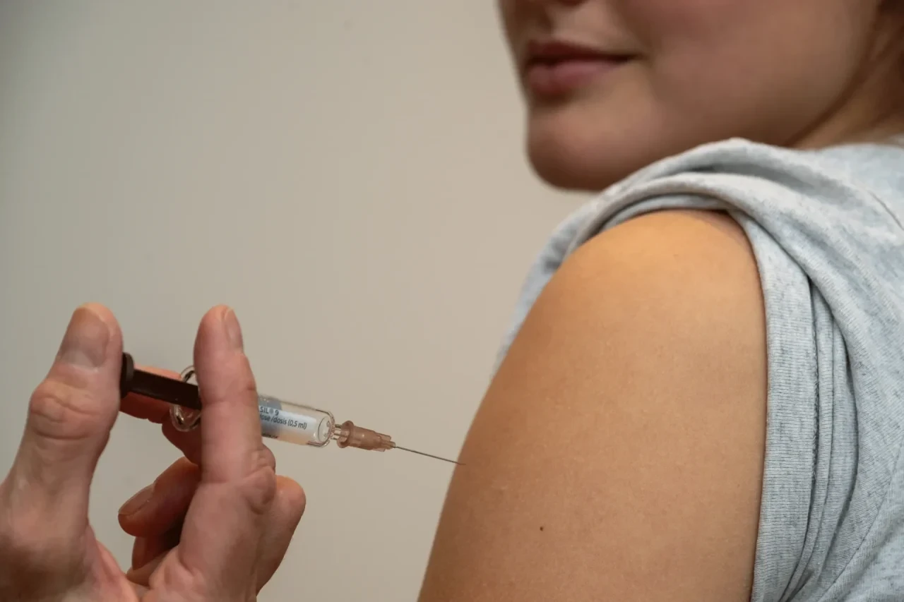 Junge Frau erhält Impfung in den Arm