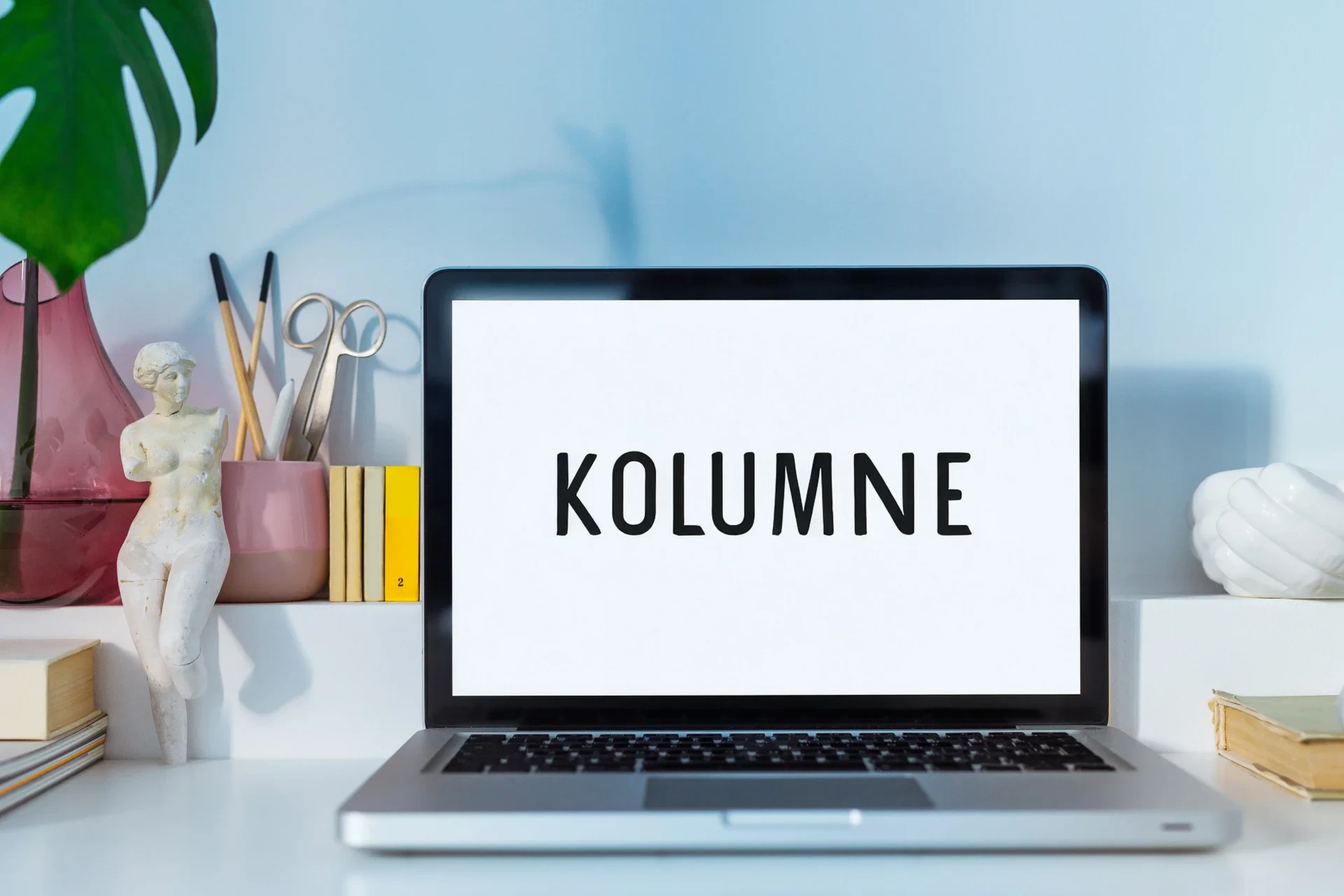 Schreibtisch mit Laptop, der den Schriftzug Kolumne trägt