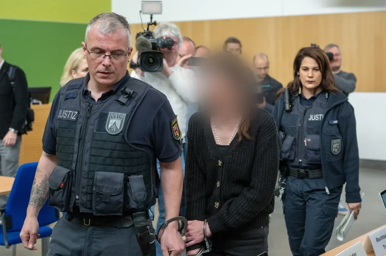 Rheinland-Pfalz, Trier: Die Lebensgefährtin (M) eines Gerolsteiner Arztes wird von Justizbediensteten zur Anklagebank geführt. Sie ist wegen gemeinschaftlichem Totschlag angeklagt.