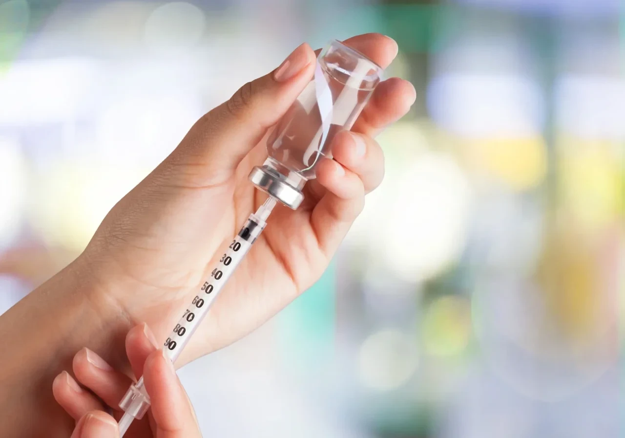 Hand hält Spritze vor unscharfem Hintergrund
