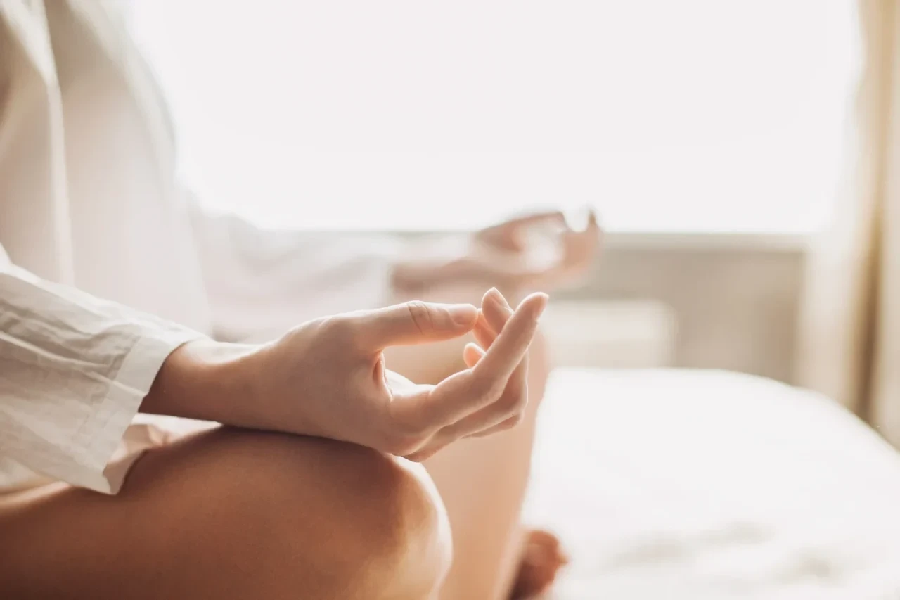 Person in ruhiger Meditationshaltung auf einer Yogamatte