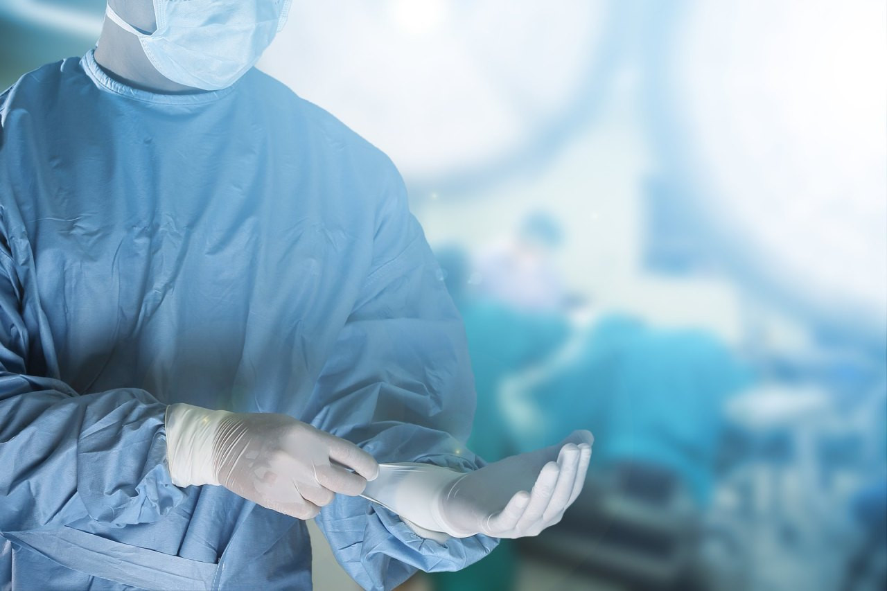 Arzt zieht Handschuh im OP an