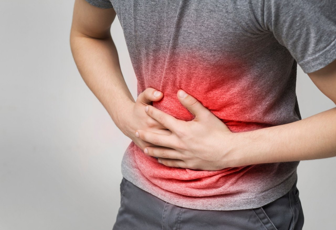 Mann hält sich Bauch mit beiden Händen