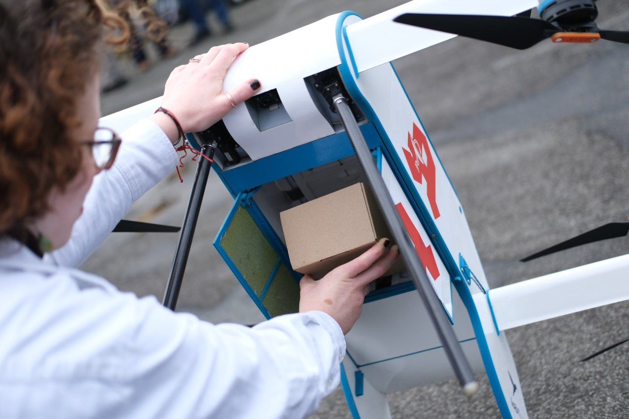 Eine Drohne vom Typ Labfly wird während einer Präsentation mit Transportgut bestückt. Anlass ist eine Versorgungsstudie zum geplanten Einsatz der Fluggeräte zur Patientenversorgung.