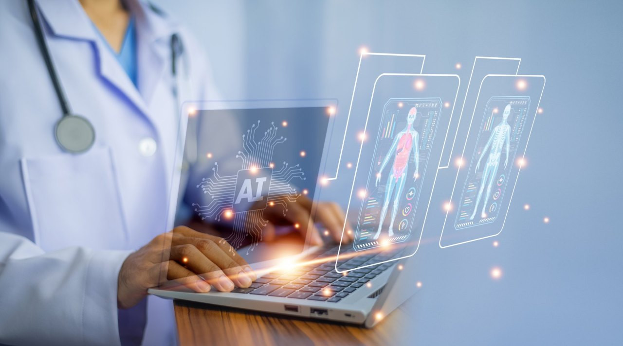 Eine medizinische Fachkraft arbeitet an einem Laptop. Auf dem Bildschirm und davor erscheinen holografische Darstellungen eines stilisierten menschlichen Körpers mit medizinischen Daten sowie ein Symbol für künstliche Intelligenz