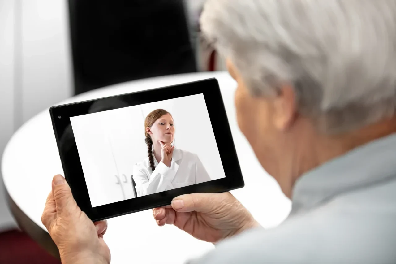 Alte Patientin betrachtet Tablet mit medizinischen Anleitungen