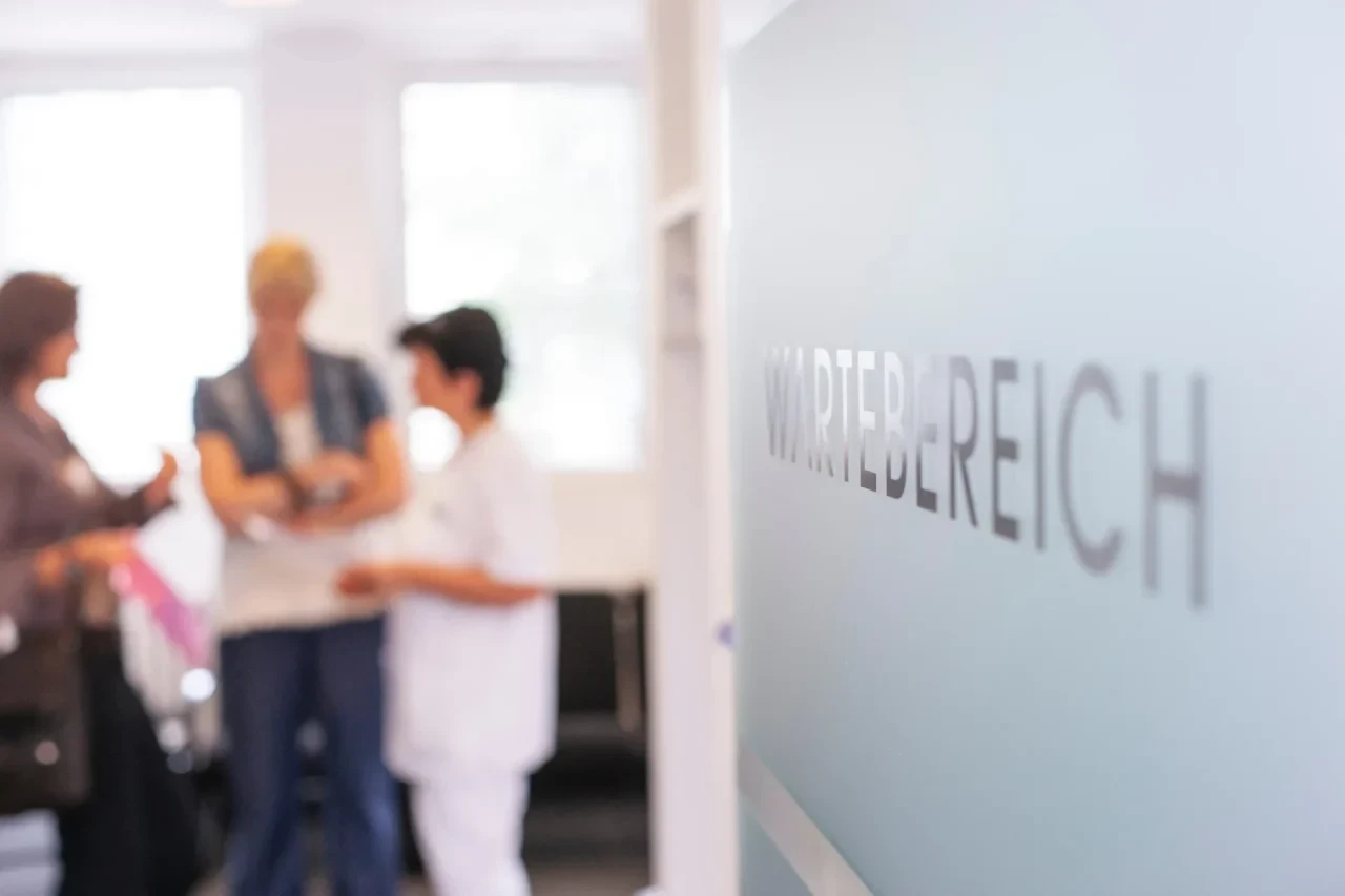 Wartebereich mit Patientinnen und Ärztin im Hintergrund