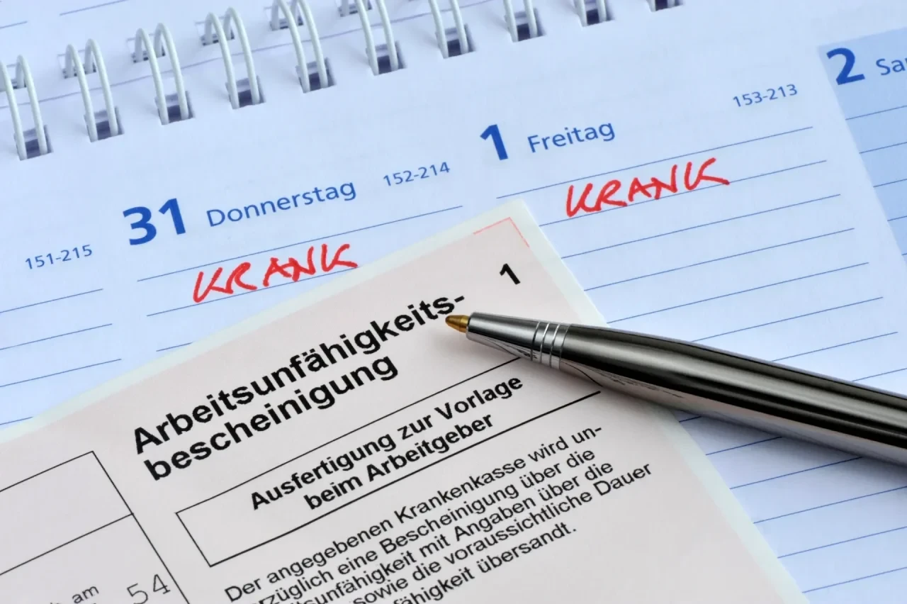 Arbeitsunfähigkeitsbescheinigung und Kalender mit Vermerk „krank"