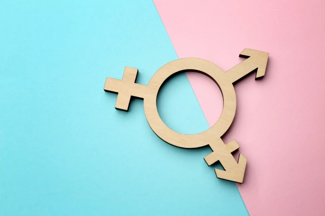 Transgender-Symbol vor rosa-blauem Hintergrund