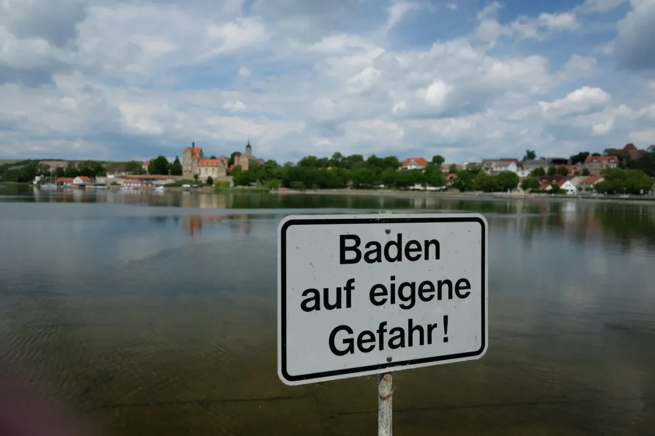 Ein Schild mit der Aufschrift „Baden auf eigene Gefahr“ steht am Ufer des Süßen Sees bei den See-Terrassen Seeburg