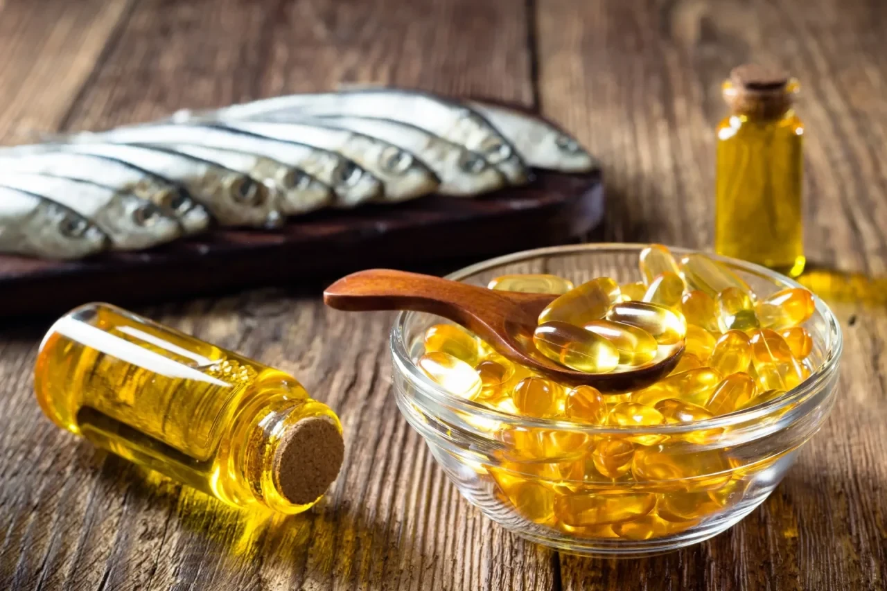 Fischölkapseln und Sardinen als Omega-3-Quellen auf Holztisch