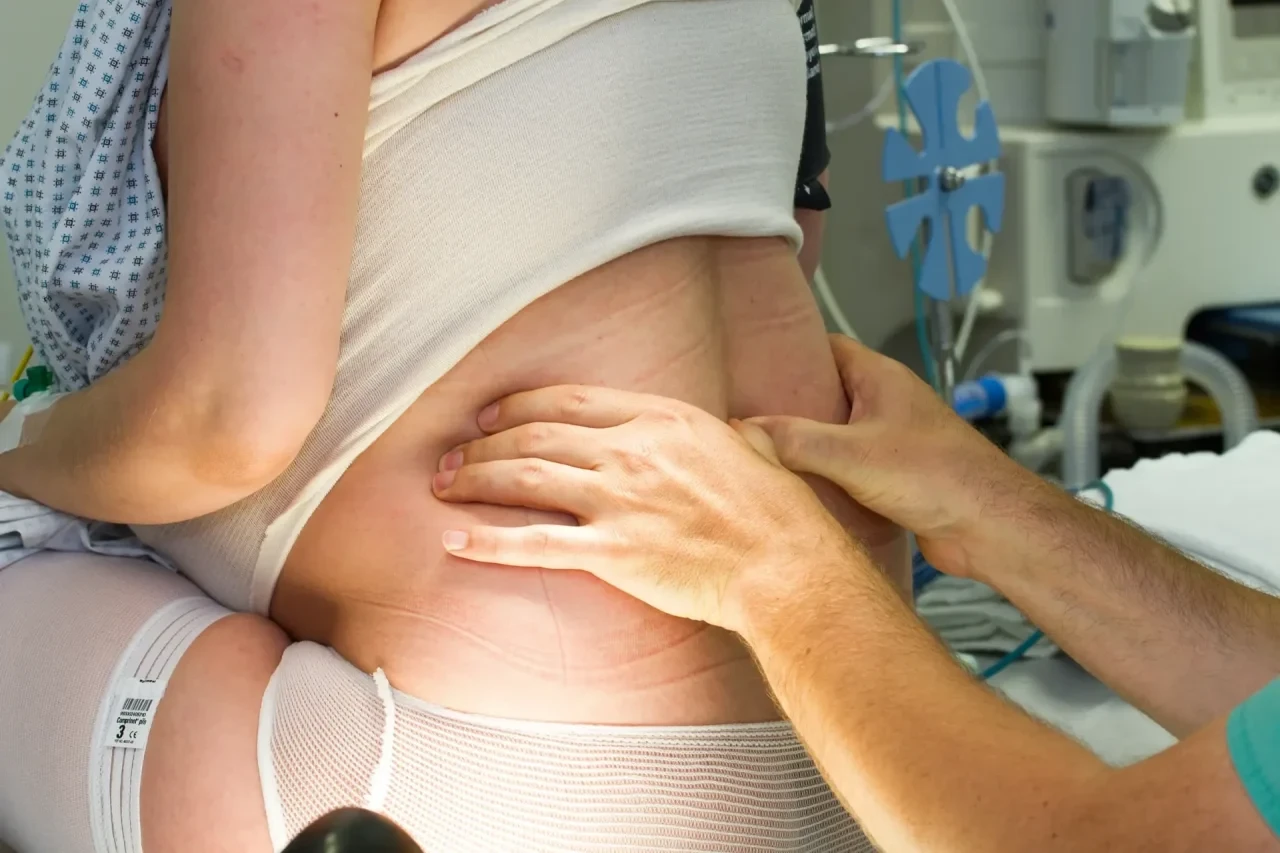 Schwangere Frau sitzt im Krankenhaus und wird auf eine PDA vorbereitet