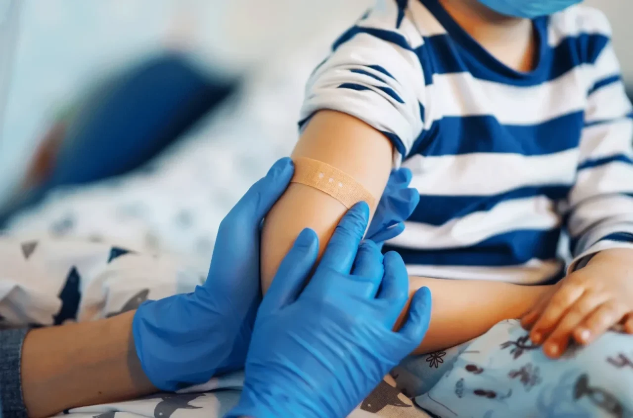 Kind kriegt Pflaster auf Arm nach Impfung