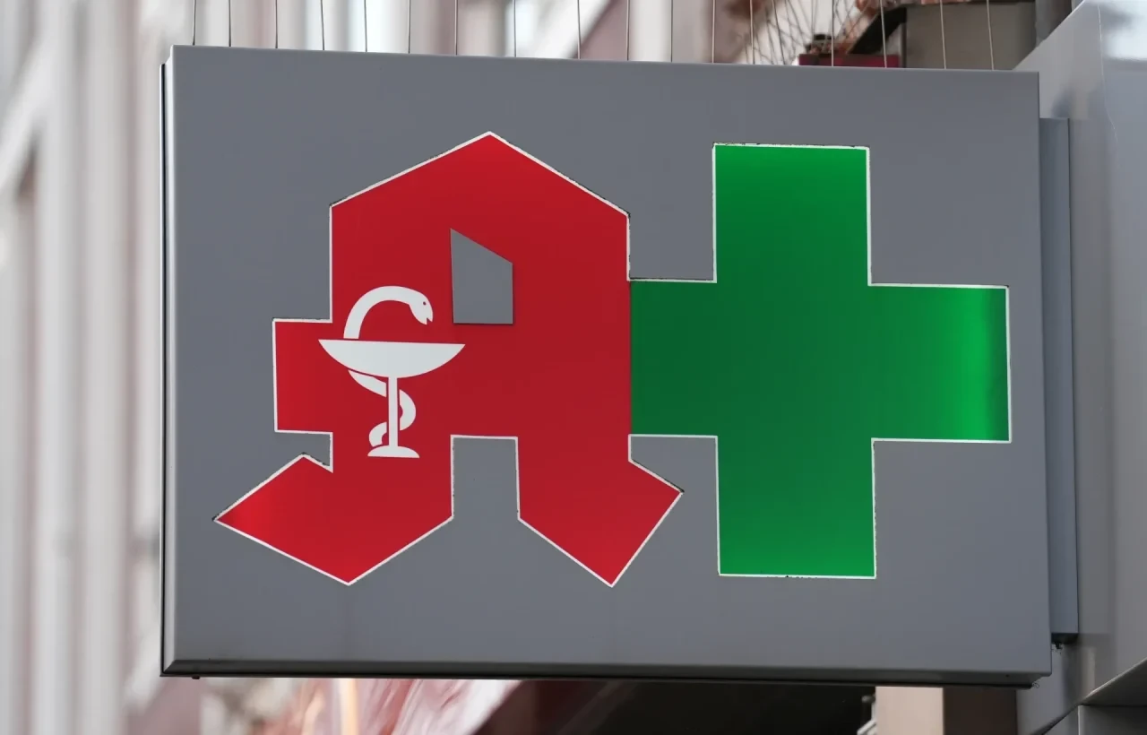 Das Logo einer Apotheke ist an einer Hausfassade über dem Geschäft zu sehen