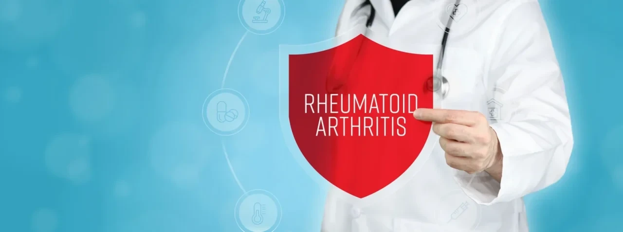 Person im weißen Arztkittel mit Stethoskop zeigt auf ein rotes Schutzschild mit der Aufschrift „Rheumatoid Arthritis“ vor blauem Hintergrund mit medizinischen Symbolen