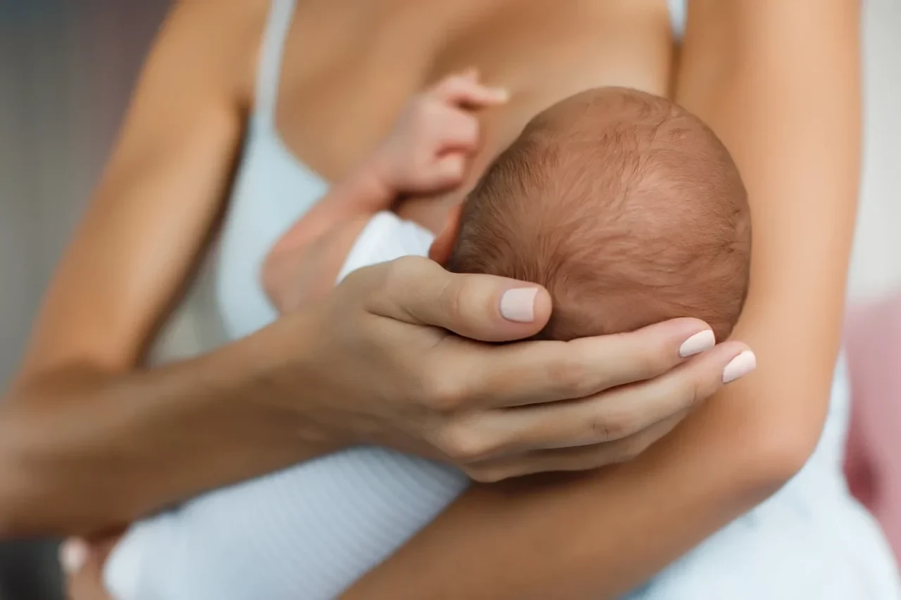 Baby wird an Brust der Mutter gestillt