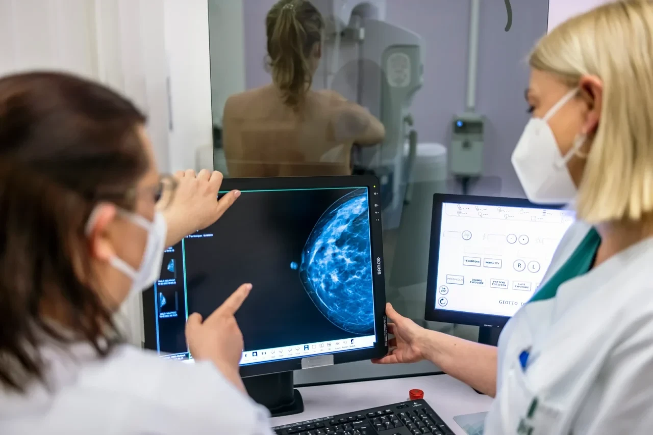 Medizinisches Personal untersucht bei einem Mammographie-Screening die Brust einer Frau auf Brustkrebs.