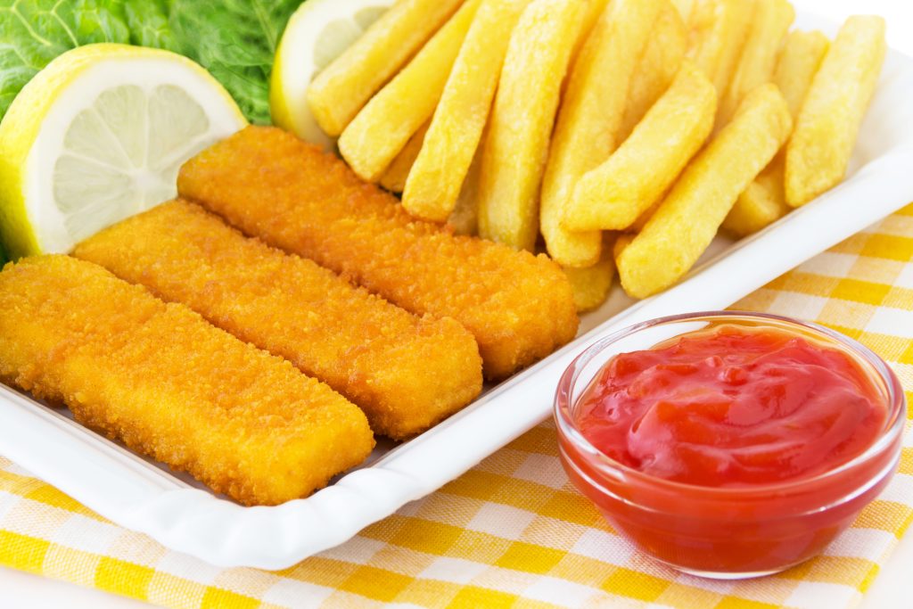 Teller mit Fischstäbchen, Pommes, Ketchup und Zitrone