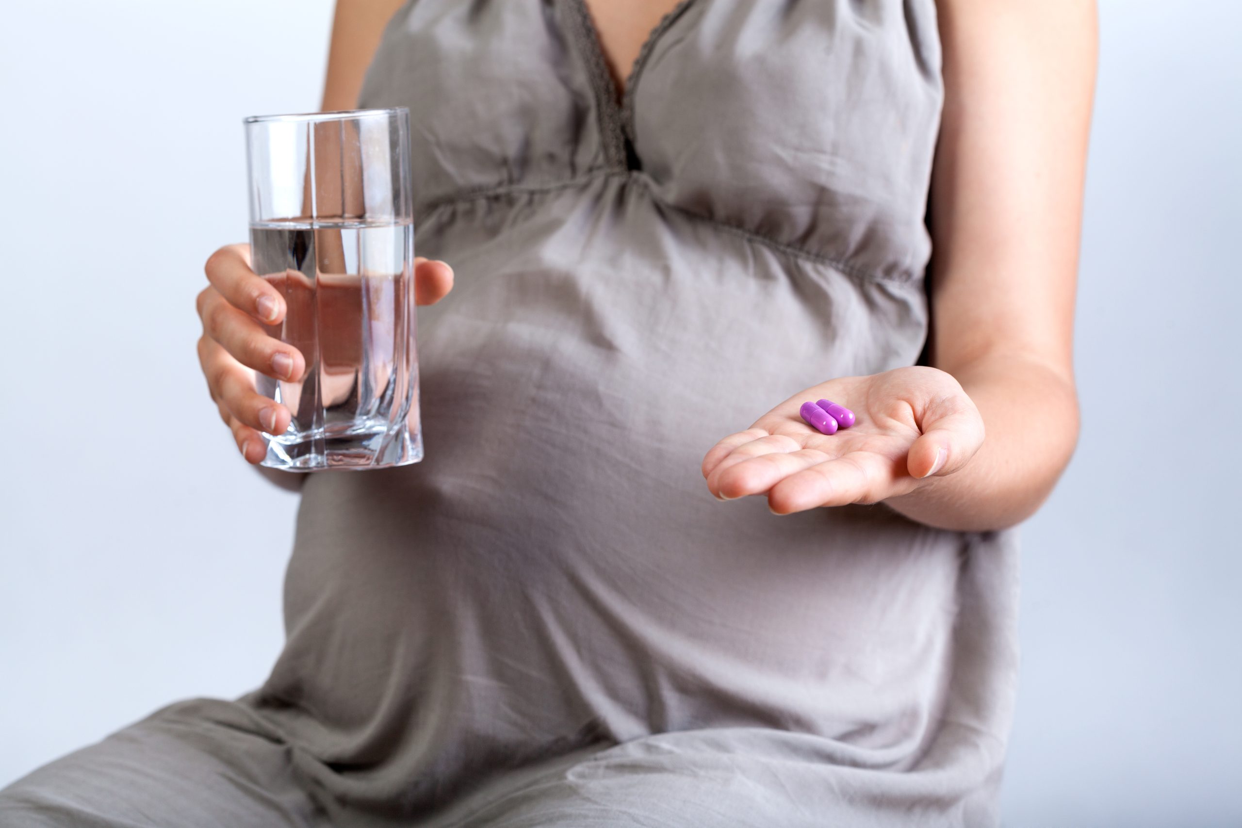 Schwangere Frau nimmt Tabletten ein