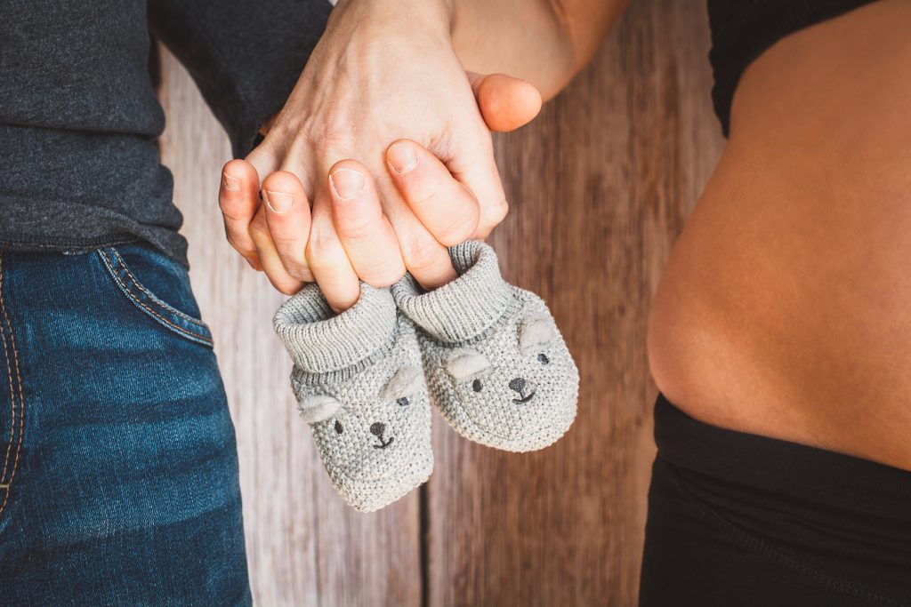 Pärchen hält Babyschuhe an den Händen