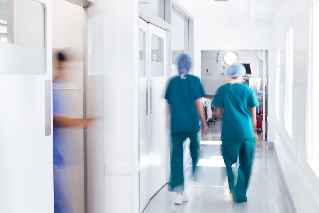 Klinikpersonal die den Flur entlang läuft
