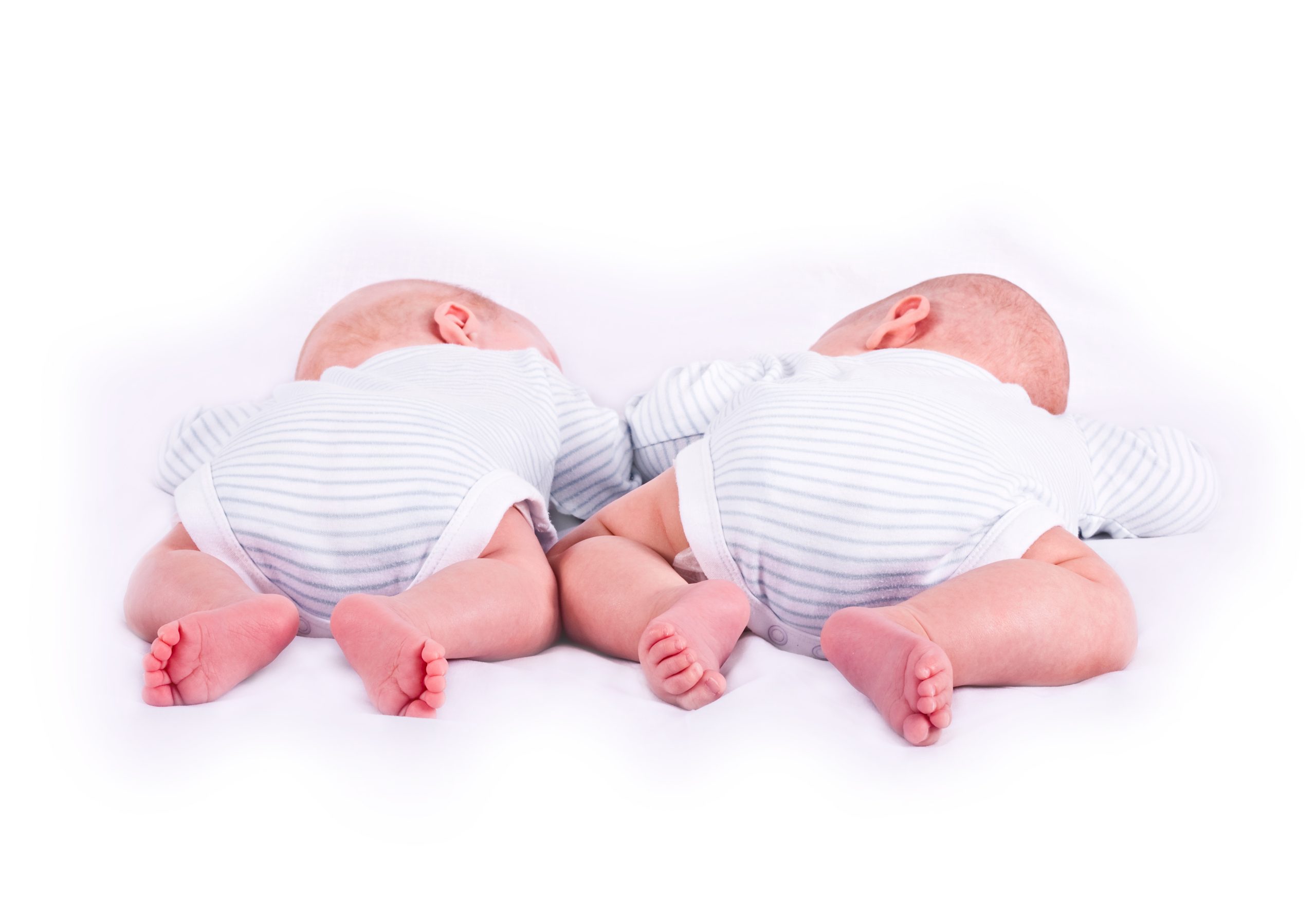 Zwillingspaar auf dem Bauch liegend