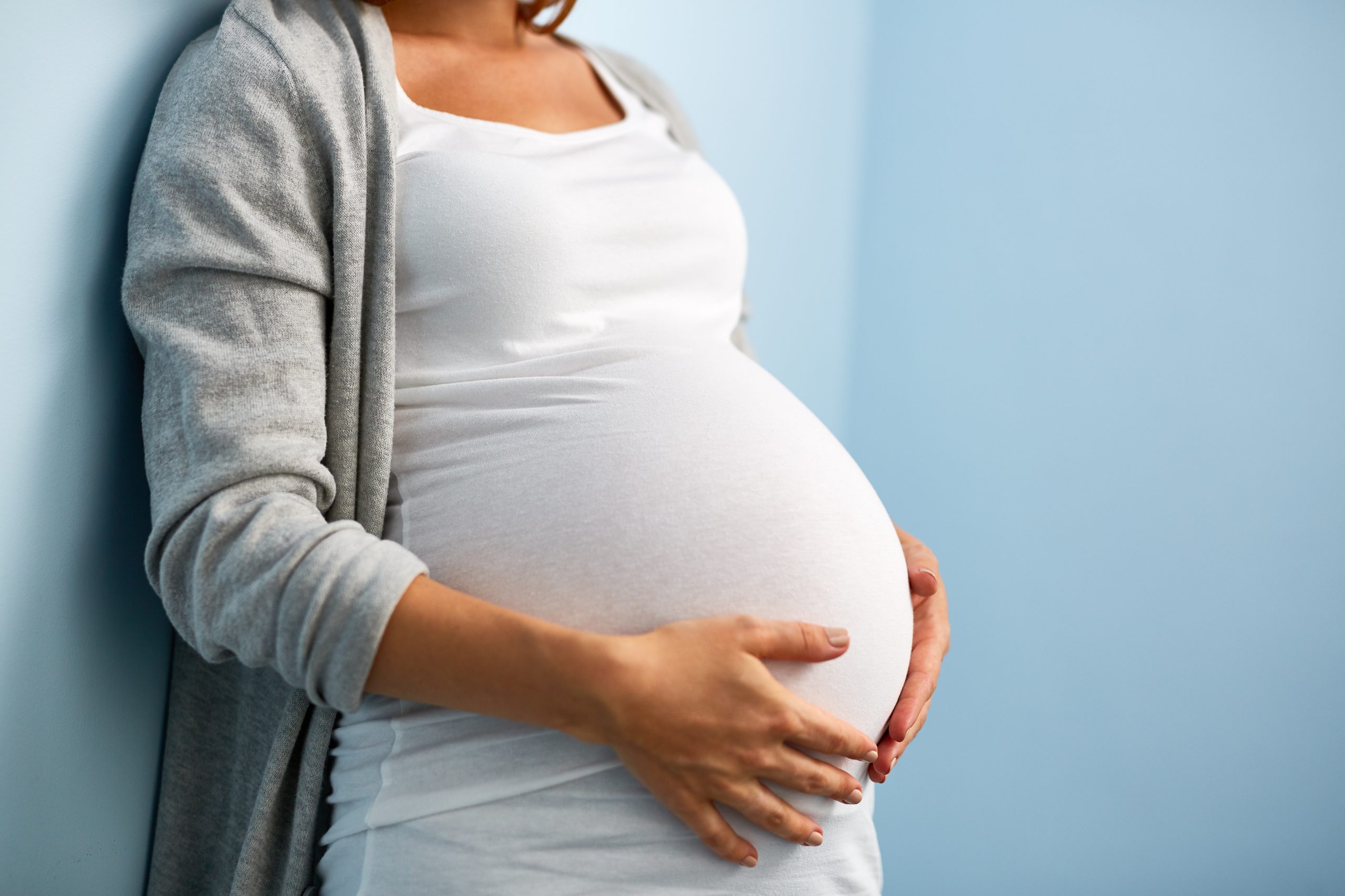 Schwangere Frau die ihren Bauch anfasst