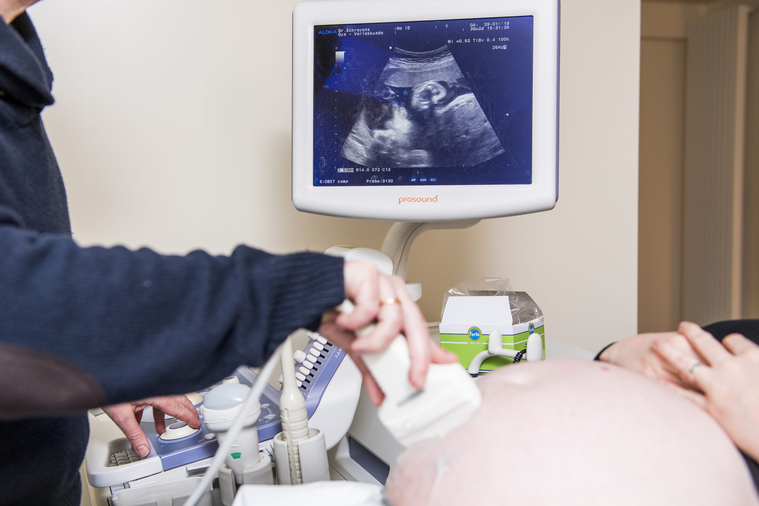 Ein Arzt untersucht eine schwangere Frau mit einem Ultraschallgerät