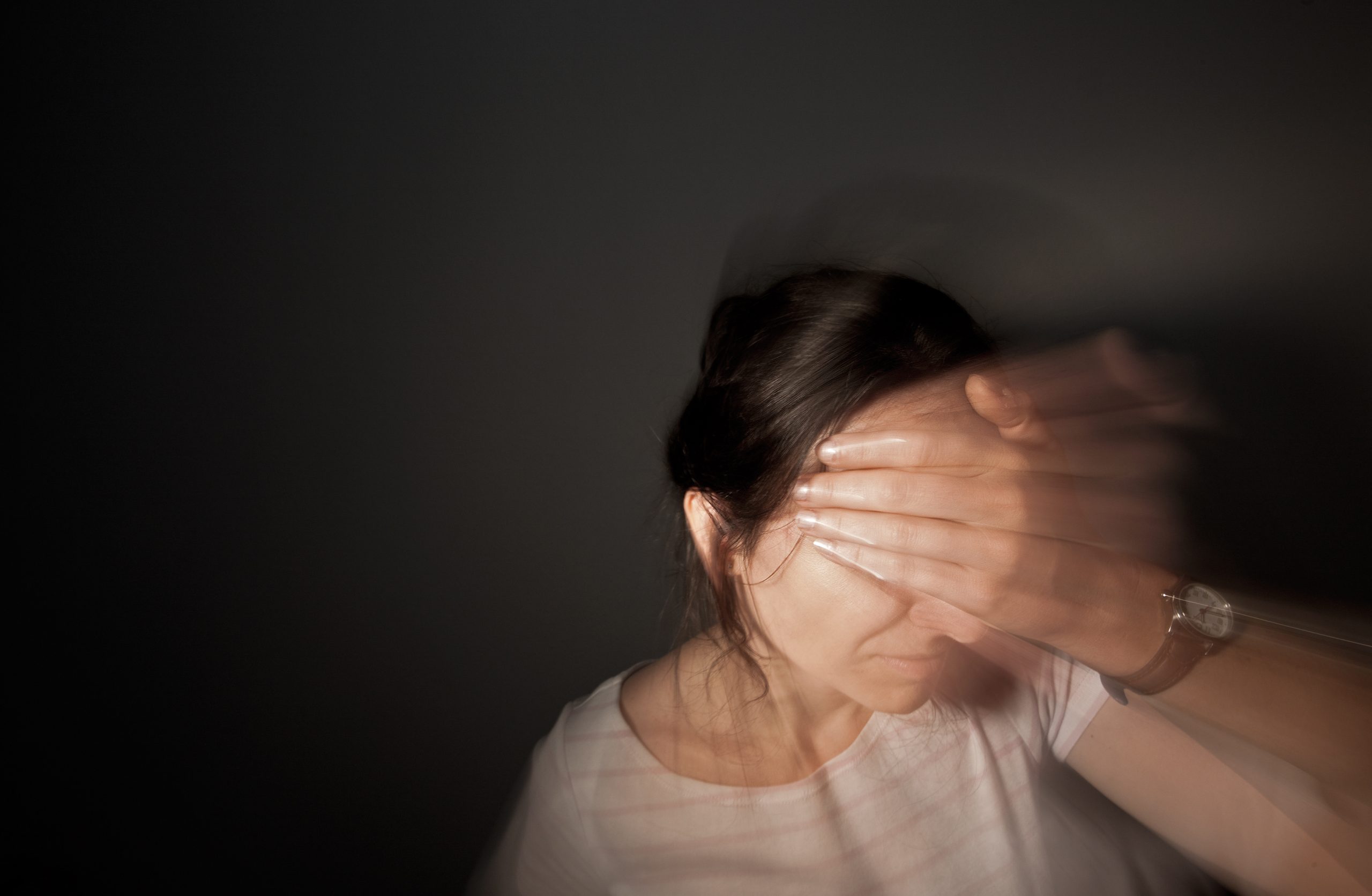 Frau die sich den Kopf hält